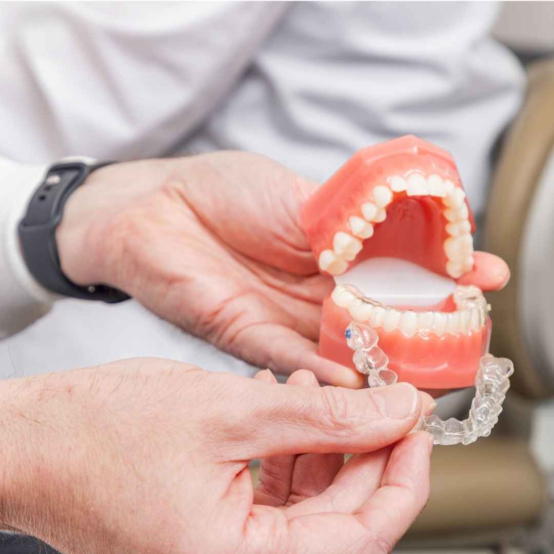 Dentist pointing at mouth model for Invisalign.